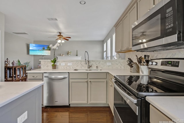 kitchen featuring ceiling fan, dark wood finished floors, light countertops, appliances with stainless steel finishes, and a sink