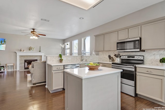 kitchen featuring stainless steel appliances, backsplash, ceiling fan, and light countertops