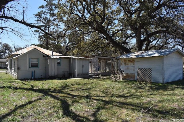 back of property with an outdoor structure and a lawn