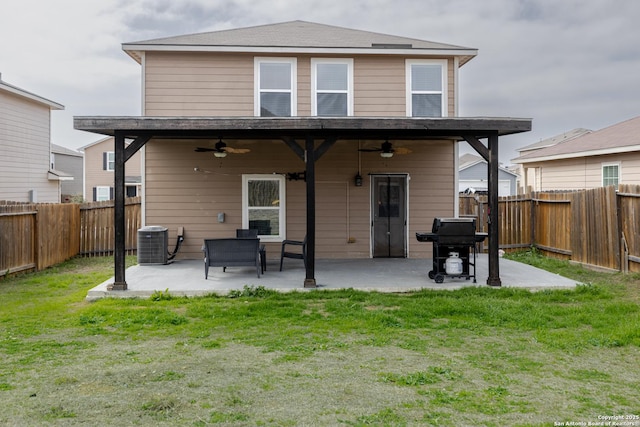 back of house with central air condition unit, a fenced backyard, a yard, ceiling fan, and a patio area