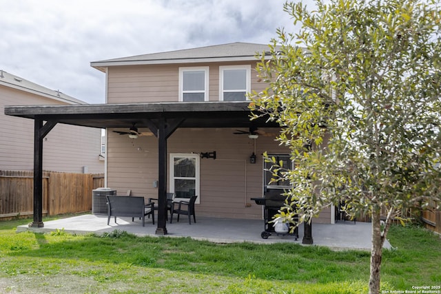 rear view of property featuring a yard, a ceiling fan, a patio, and fence