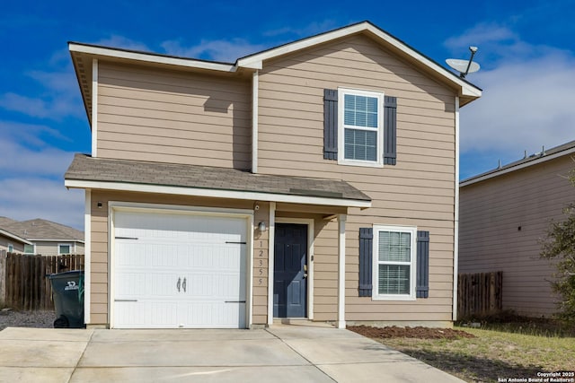 traditional-style house with a garage, driveway, and fence