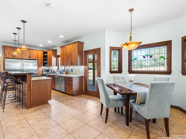 dining space with a wealth of natural light, light tile patterned floors, recessed lighting, and a toaster