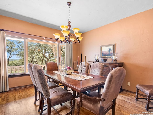 dining room featuring an inviting chandelier, light wood-style floors, and a wealth of natural light