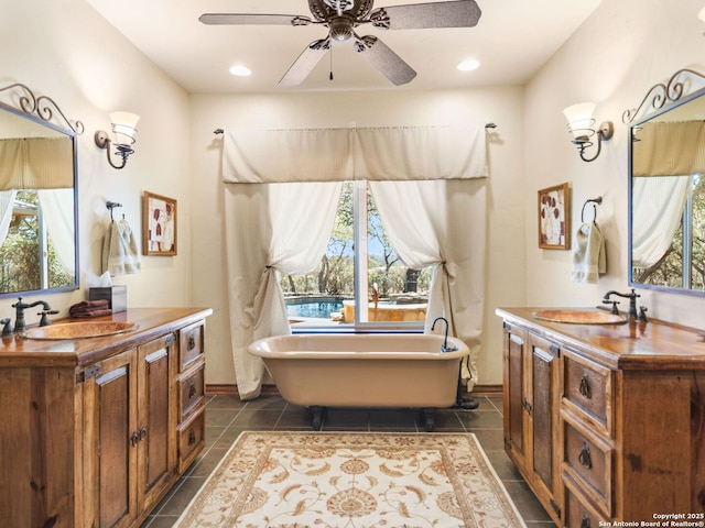 full bathroom with two vanities, a healthy amount of sunlight, and a sink