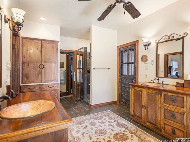 bathroom with a sink, two vanities, ceiling fan, and tile patterned flooring