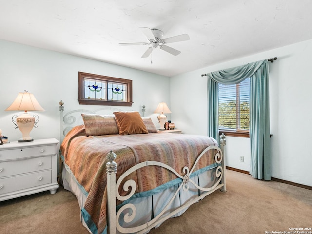 bedroom featuring light colored carpet, baseboards, and ceiling fan