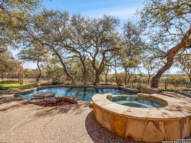 view of swimming pool with a pool with connected hot tub and fence