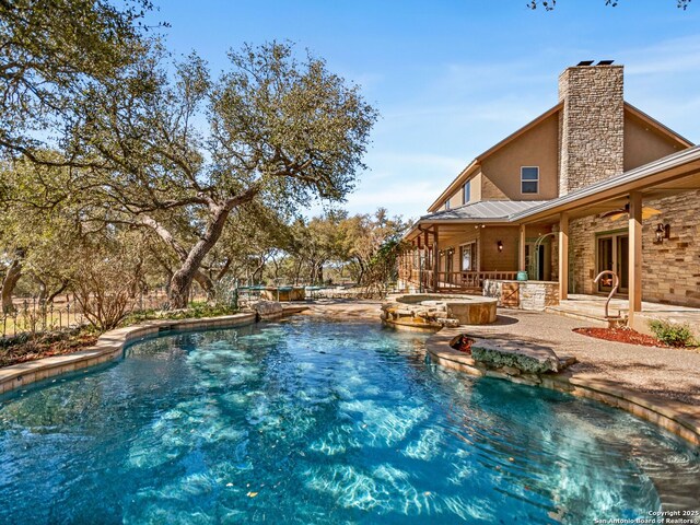 pool featuring a patio and an in ground hot tub