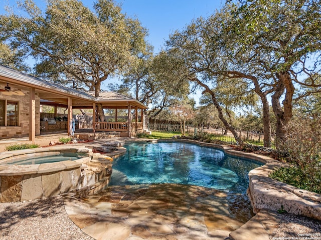 view of pool featuring ceiling fan, a patio, a pool with connected hot tub, and a fenced backyard