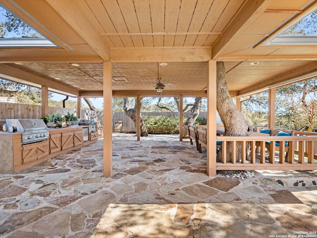 view of patio with area for grilling, a grill, and fence