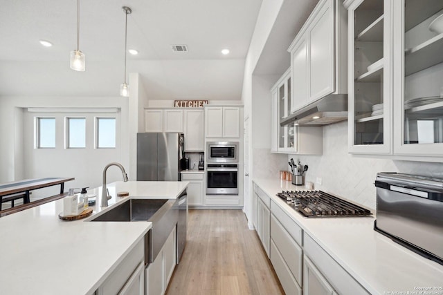 kitchen with visible vents, pendant lighting, stainless steel appliances, and light countertops