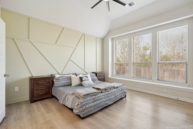 bedroom with light wood finished floors, visible vents, ceiling fan, baseboards, and lofted ceiling