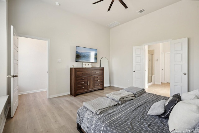 bedroom with a high ceiling, baseboards, visible vents, and light wood finished floors