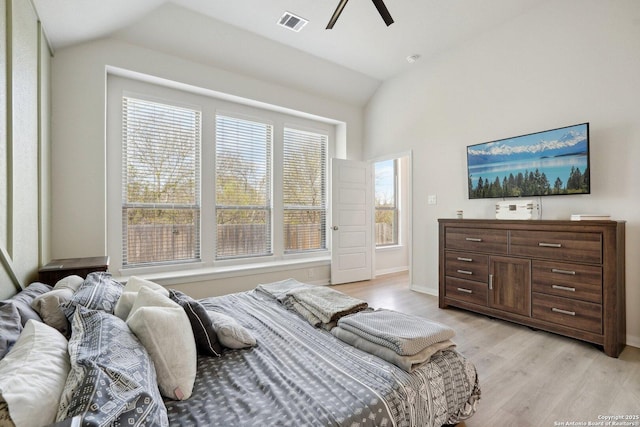 bedroom featuring visible vents, baseboards, lofted ceiling, light wood-style flooring, and a ceiling fan