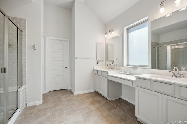 full bath featuring a shower stall, vaulted ceiling, double vanity, and a sink