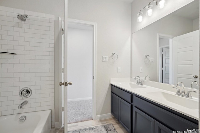 full bathroom featuring double vanity, wood finished floors, shower / bathtub combination, and a sink