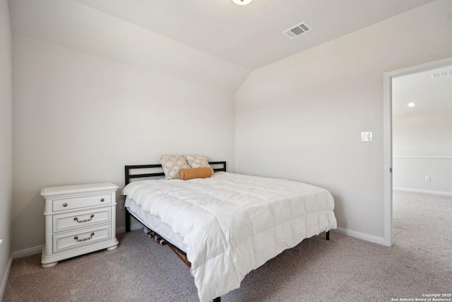 carpeted bedroom with visible vents, baseboards, and vaulted ceiling