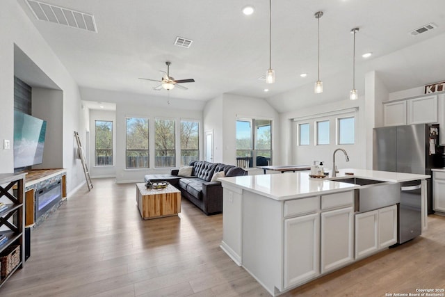 kitchen featuring visible vents, appliances with stainless steel finishes, and a kitchen island with sink