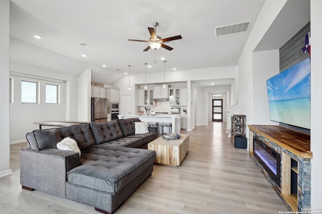 living room featuring light wood-type flooring, visible vents, a ceiling fan, recessed lighting, and vaulted ceiling