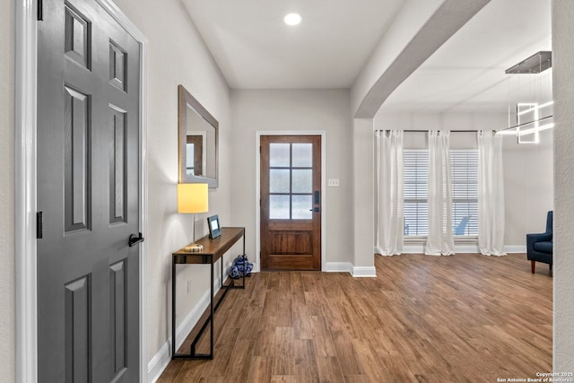 foyer entrance featuring baseboards and wood finished floors