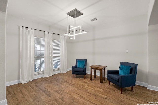 sitting room featuring visible vents, baseboards, and wood finished floors