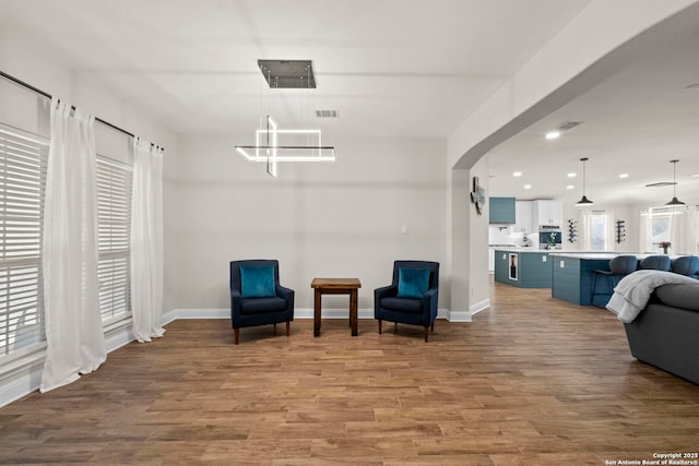 sitting room featuring recessed lighting, baseboards, arched walkways, and wood finished floors