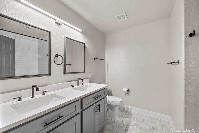 bathroom with double vanity, visible vents, toilet, and a sink