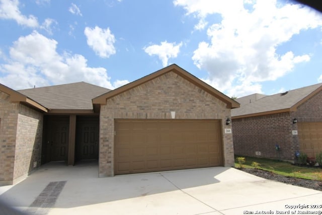 ranch-style home with a garage, brick siding, and driveway