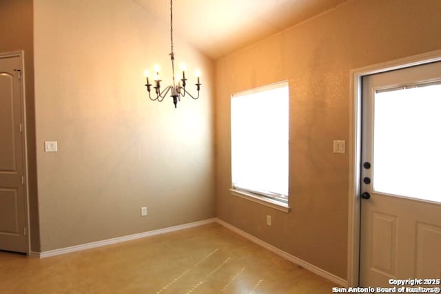 unfurnished dining area featuring an inviting chandelier and baseboards