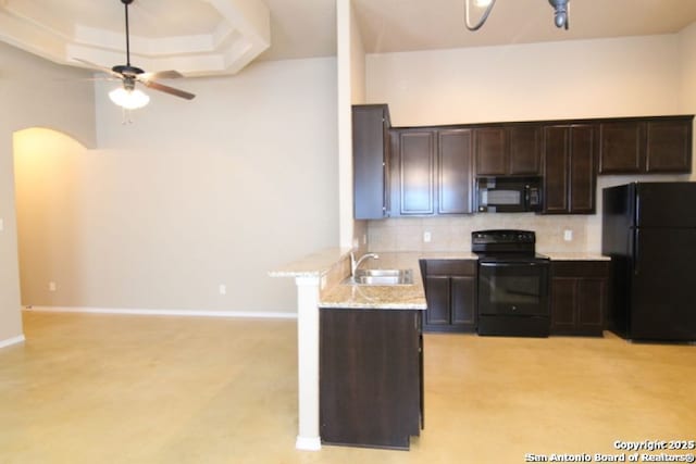 kitchen featuring tasteful backsplash, dark brown cabinets, ceiling fan, black appliances, and a sink