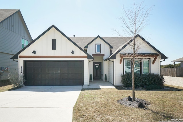 modern farmhouse style home featuring driveway, fence, board and batten siding, a front yard, and a garage