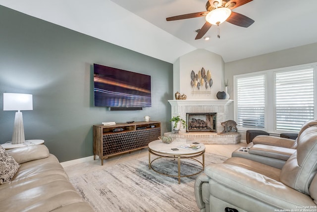 tiled living area featuring lofted ceiling, a brick fireplace, baseboards, and ceiling fan