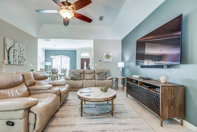 living area featuring light tile patterned flooring, visible vents, ceiling fan with notable chandelier, and baseboards