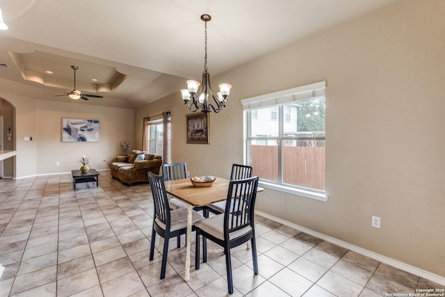 dining area with baseboards, light tile patterned floors, ceiling fan with notable chandelier, and arched walkways
