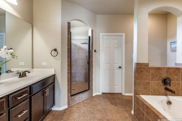 bathroom featuring a shower stall, a garden tub, tile patterned flooring, and vanity