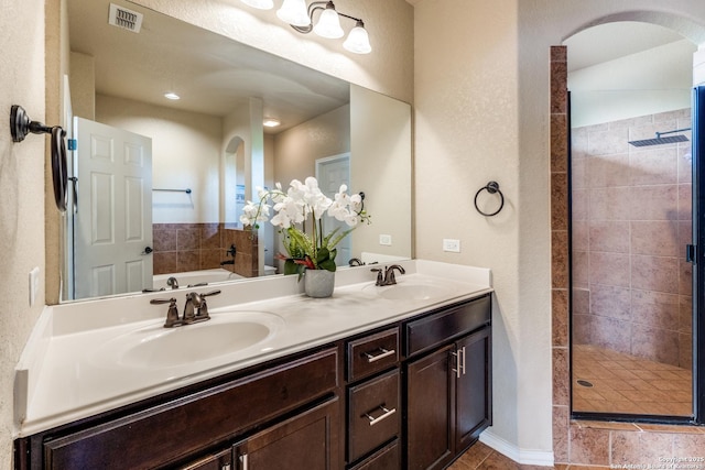 full bathroom featuring visible vents, a shower stall, and a sink