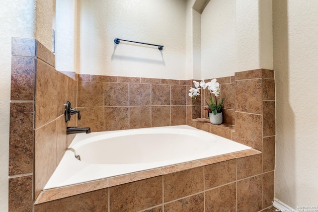 bathroom featuring a garden tub and a textured wall