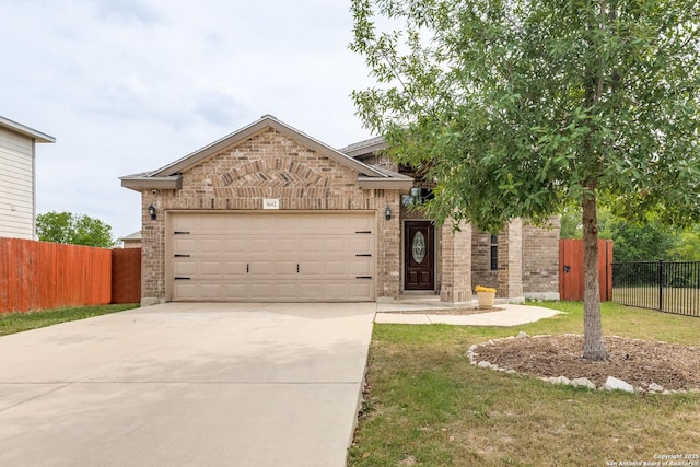view of front of home with driveway, fence, brick siding, and an attached garage