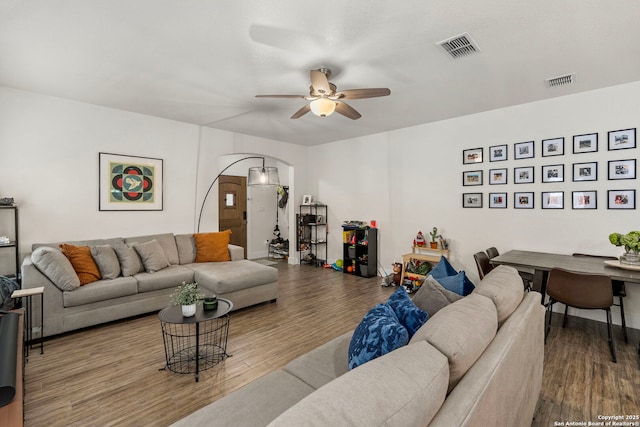 living area with wood finished floors, a ceiling fan, and visible vents