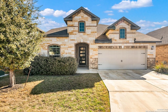 french country inspired facade with a front lawn, concrete driveway, roof with shingles, stone siding, and an attached garage