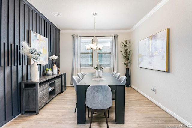 dining area featuring visible vents, baseboards, a chandelier, ornamental molding, and light wood-style flooring