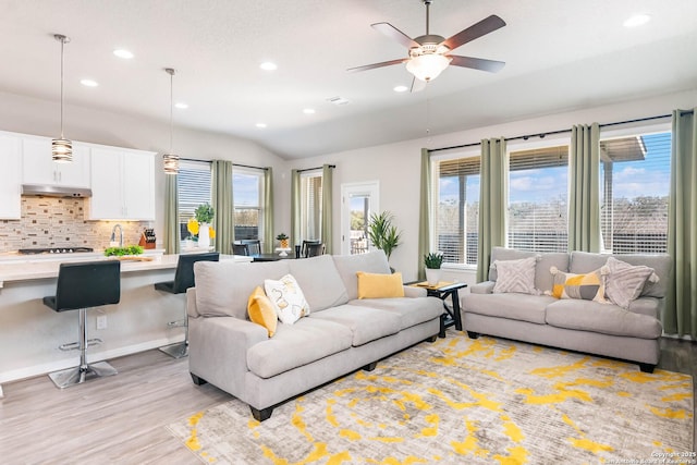 living area with vaulted ceiling, light wood-style flooring, recessed lighting, and a ceiling fan