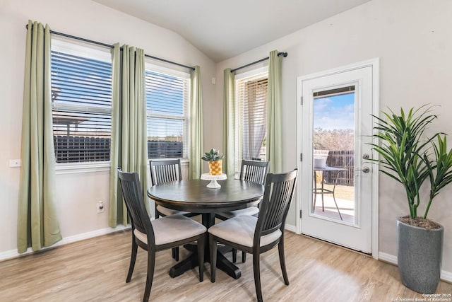 dining area with vaulted ceiling, light wood-type flooring, and a wealth of natural light