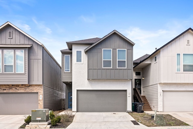 view of front of property featuring a garage, board and batten siding, concrete driveway, and stairway