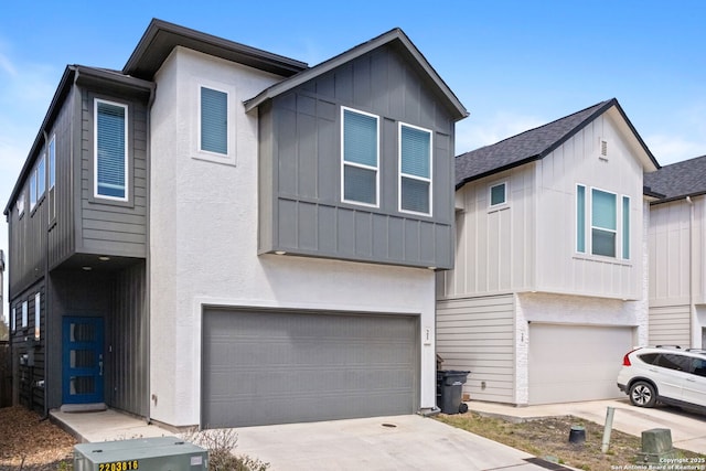 view of front facade featuring stucco siding, driveway, board and batten siding, and an attached garage