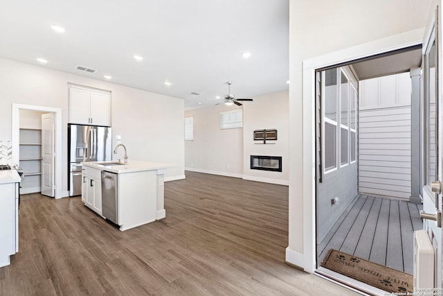 kitchen featuring visible vents, a ceiling fan, a sink, wood finished floors, and appliances with stainless steel finishes