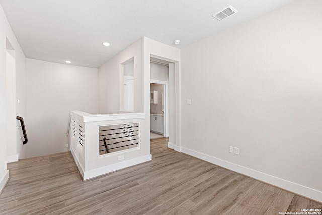 spare room with visible vents, recessed lighting, light wood-type flooring, and baseboards