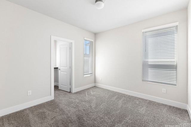 empty room featuring carpet flooring and baseboards