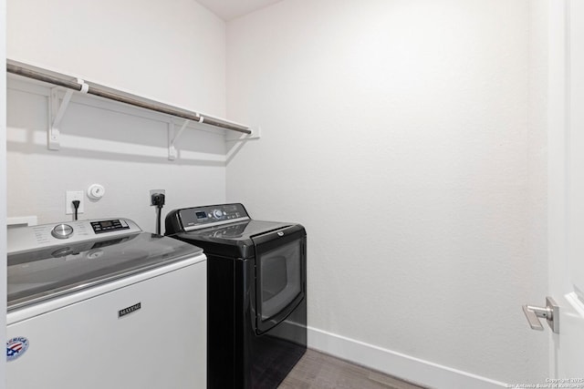 clothes washing area featuring laundry area, washing machine and dryer, light wood-type flooring, and baseboards